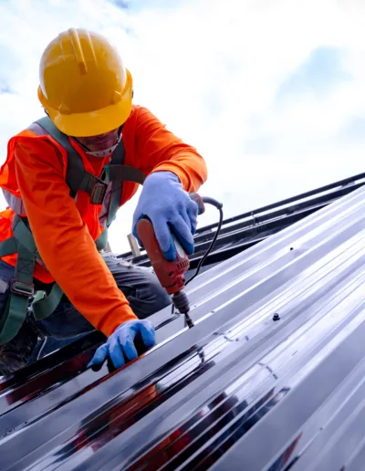 A worker is working on a metal roof.